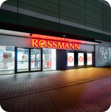 Oświetlona witryna sklepu Rossmann wieczorem